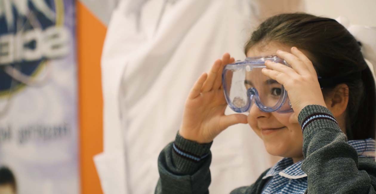 Girl smiling while wearing safety goggles
